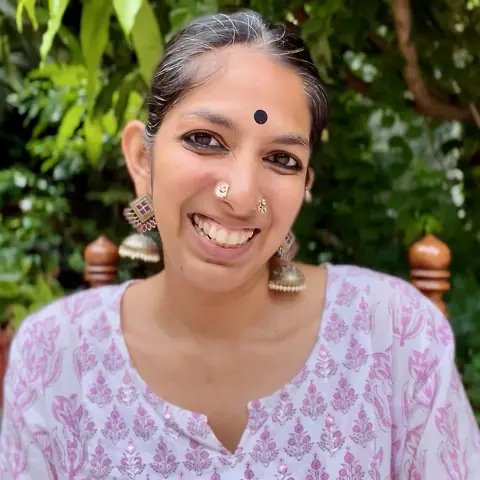 Priya smiling in a garden